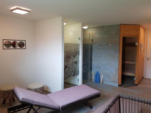 Habitación con banco púrpura y ducha a ras de suelo. en Panorama Lodge, en Scuol