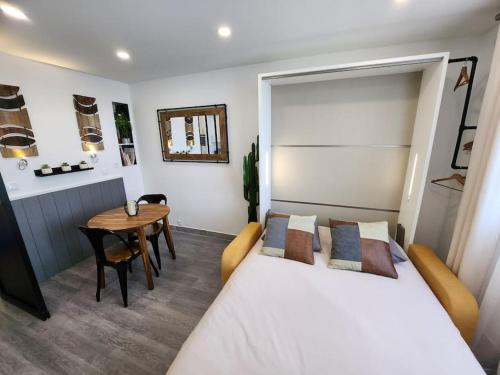 um quarto com uma cama branca e uma mesa em Le Repaire - Studio avec parking à 550m de la mer em Houlgate