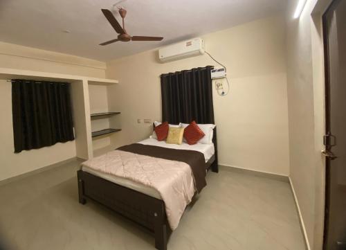 1 dormitorio con 1 cama y ventilador de techo en Ocean Shores en Chennai