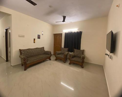 a living room with two couches and a tv at Ocean Shores in Chennai