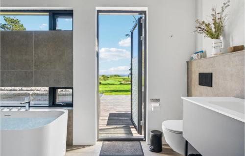 a bathroom with a tub and a view of the ocean at Cozy Home In Hjslev With Wifi in Højslev