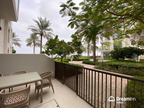 a balcony with a table and chairs and palm trees at Dream Inn Apartments - Address Beach Residence Fujairah in Fujairah