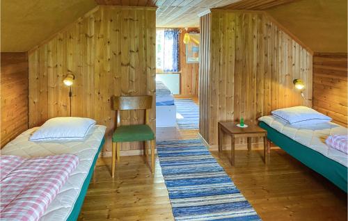twee bedden in een kamer met houten wanden bij Amazing Home In Vimmerby With Indoor Swimming Pool in Vimmerby