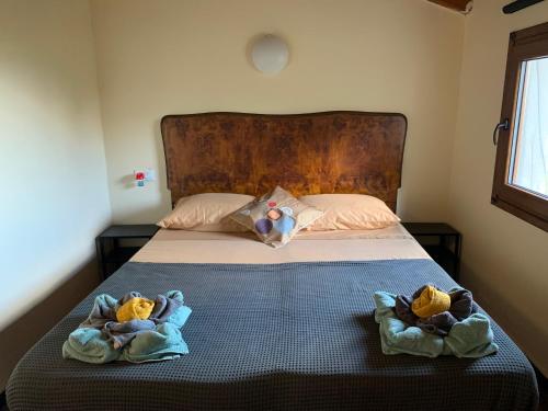 dois bichos de peluche estão sentados numa cama em Monolocali del Montecontessa by SMART-HOME 