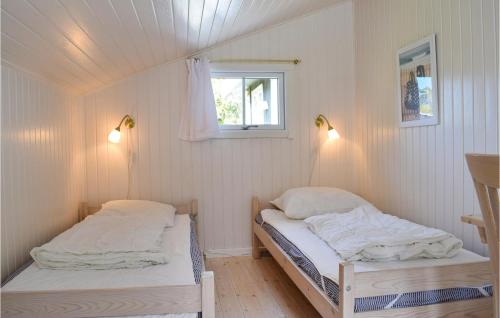 two beds in a small room with a window at Gorgeous Home In Dronningmlle With Wifi in Dronningmølle
