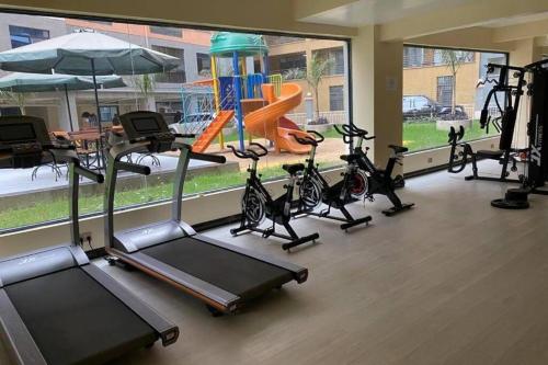 een fitnessruimte met diverse loopbanden en hometrainers bij Lux Suites Kileleshwa Business Studio Apartment in Nairobi
