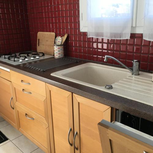 une cuisine avec un évier et une cuisinière dans l'établissement Villa HESTIA, au Teich