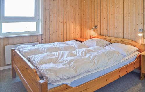 a large wooden bed with white sheets and pillows at Stunning Home In Thisted With Sauna in Klitmøller