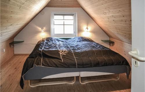 een bed in het midden van een kamer met een raam bij Nice Home In Oksbl With Sauna in Mosevrå