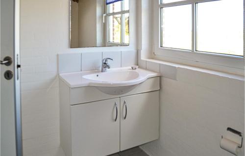 een badkamer met een wastafel en een raam bij Nice Home In Oksbl With Sauna in Mosevrå