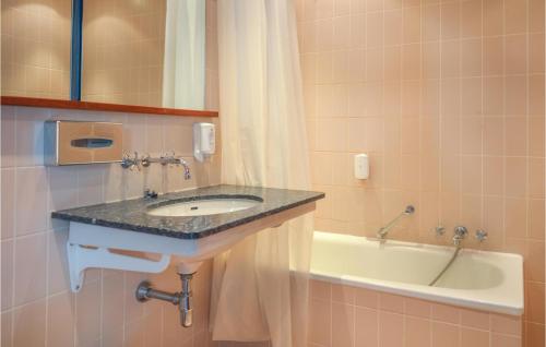 uma casa de banho com um lavatório e uma banheira em Cozy Apartment In Helsingr With Kitchen em Helsingor