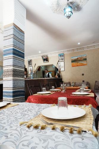 a dining room with two tables with red table cloth at Hotel De La Vallée in Aït Baha