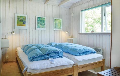 a bed with blue pillows on it in a room at Beautiful Home In Vejby With 3 Bedrooms, Sauna And Wifi in Vejby