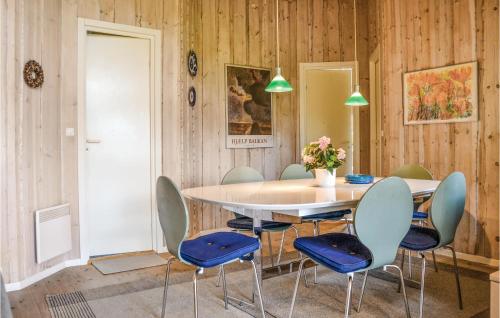 a dining room with a table and blue chairs at Four-Bedroom Holiday Home In Dronningmolle in Dronningmølle