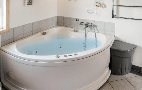 a white bath tub in a bathroom with a trash can at Awesome Home In Thisted With 4 Bedrooms, Sauna And Wifi in Nørre Vorupør