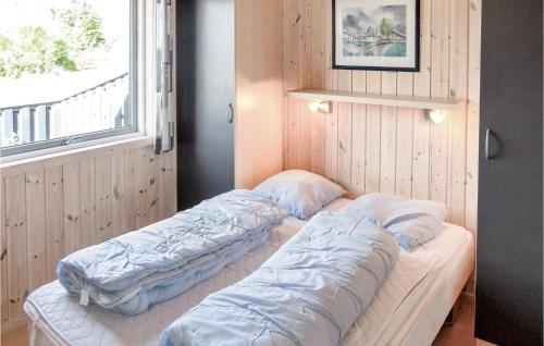 two beds in a room with a window at Awesome Home In Thisted With 4 Bedrooms, Sauna And Wifi in Nørre Vorupør