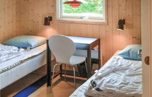 Cette chambre comprend deux lits, un bureau et une chaise. dans l'établissement Stunning Home In Gilleleje With 4 Bedrooms, Sauna And Wifi, à Gilleleje