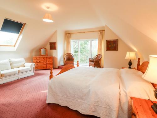 um quarto com uma grande cama branca e um sofá em Seascape Lodge em Kenmare