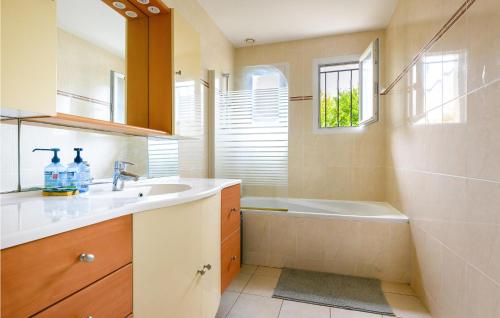 ein Badezimmer mit einem Waschbecken und einer Badewanne in der Unterkunft Amazing Home In Jou Les Tours With Kitchen in Joue-les-Tours