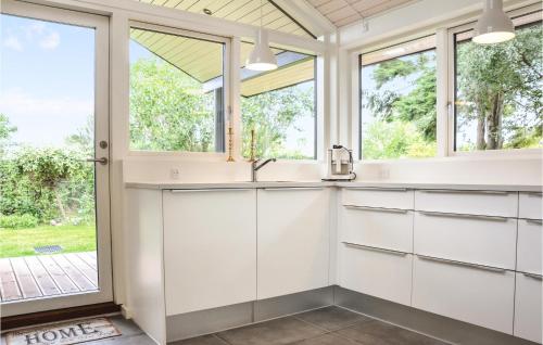 eine Küche mit weißen Schränken und Fenstern in der Unterkunft Gorgeous Home In Dronningmlle With Wifi in Dronningmølle