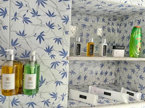 - une étagère dans la salle de bains avec des bouteilles d'odorisants dans l'établissement Airbnb x Divine Stay, à Mathura