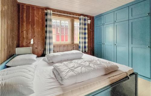 a large bed in a room with blue walls at Lovely Home In Svingvoll With Sauna in Svingvoll