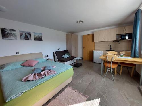 a bedroom with a bed and a desk and a kitchen at Studio apartma Žirovnik in Cerklje na Gorenjskem