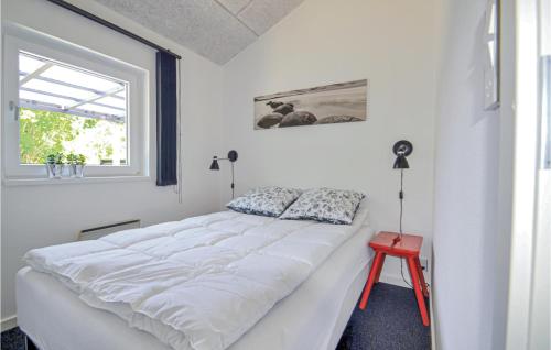 AllingåbroにあるStunning Home In Allingbro With 2 Bedroomsの白いベッドルーム(大型ベッド1台、赤いスツール付)