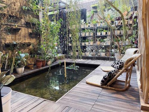 a patio with a pool of water with a chair and plants at Teras Sabin in Ngabean