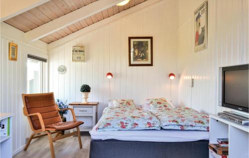 Bjerregårdにある2 Bedroom Nice Home In Hvide Sandeのベッドルーム(ベッド1台、椅子、テレビ付)