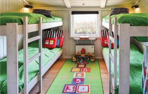 オテルプにあるAwesome Home In Otterup With 4 Bedrooms, Sauna And Wifiの二段ベッド2台とラグが備わる客室です。