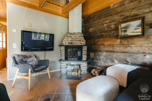 un salon avec une cheminée et une télévision dans l'établissement Holiday in Lapland - Levin Sudenpesä, à Levi