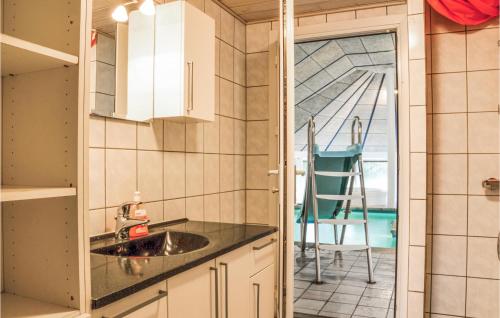 a kitchen with a sink and a view of a room at Amazing Home In Ringkbing With Kitchen in Søndervig