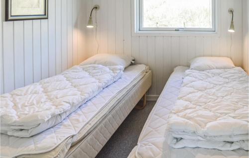two beds in a room with white walls at Cozy Home In Harbore With House A Panoramic View in Harboør
