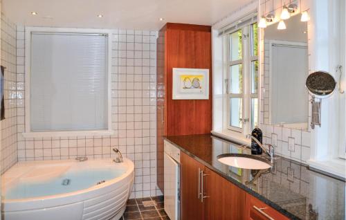 a bathroom with a large tub and a sink at Amazing Home In Hornbk With Wifi in Hornbæk