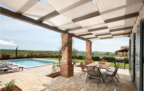 un patio avec une table et des chaises et une piscine dans l'établissement Villa Adastra, à Sveti Lovreč Pazenatički