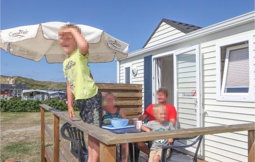 ヴィデ・サンデにあるAmazing Home In Hvide Sande With 2 Bedrooms, Wifi And Indoor Swimming Poolの二人の少年が傘の下に座っている