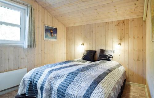 a bedroom with a bed in a wooden wall at Gorgeous Home In Blvand With Kitchen in Blåvand