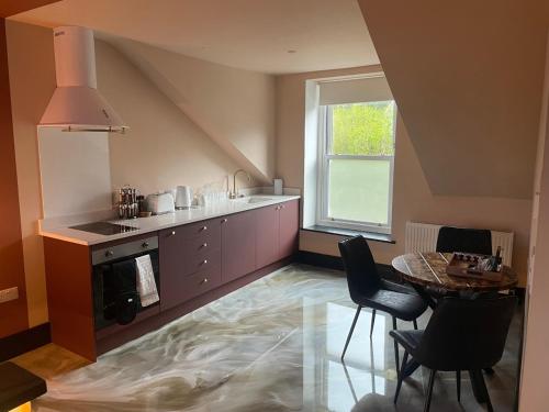 a kitchen with a table and a stove and a window at Craig Walk Suite in Bowness-on-Windermere