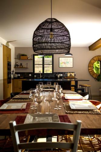 une salle à manger avec une grande table en bois et des verres à vin dans l'établissement Gite Le Clos Sainton, à Saint-Hilaire-Saint-Mesmin