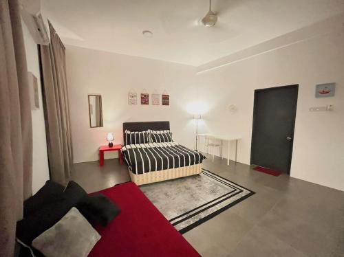salon z łóżkiem i czerwonym dywanem w obiekcie Immense Studio EmpireDamansara/WiFi/Netflix w mieście Petaling Jaya