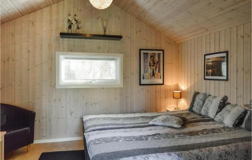1 dormitorio con 1 cama en una pared de madera en 3 Bedroom Beautiful Home In Jgerspris, en Jægerspris