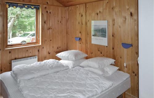 ÅlbækにあるGorgeous Home In lbk With Saunaの木製の壁のドミトリールームのベッド1台分です。
