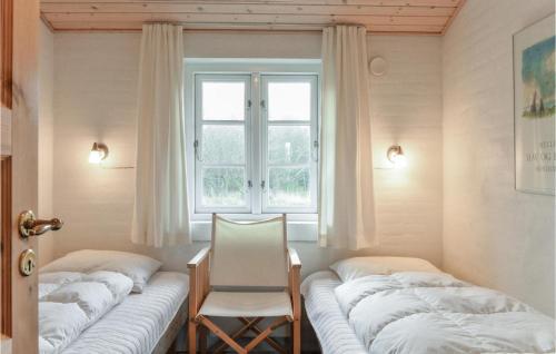 Fjand GårdeにあるHavhusetのベッド4台、椅子、窓が備わる客室です。