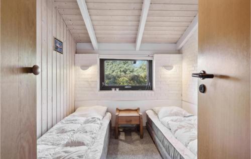 ヘンネ・ストランドにある3 Bedroom Amazing Home In Henneのベッド2台と窓が備わる小さな客室です。