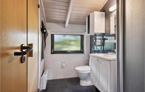 a small bathroom with a toilet and a window at Awesome Home In Henne With 3 Bedrooms And Sauna in Henne Strand