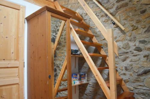 a wooden staircase in a room with a stone wall at La Grange de Cassiopée - Duplex avec vue imprenable in Les Angles