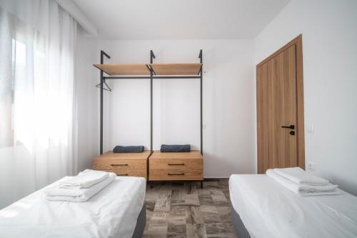 sypialnia z 2 łóżkami i drewnianą szafką w obiekcie Avli Guest House w mieście Tympáki