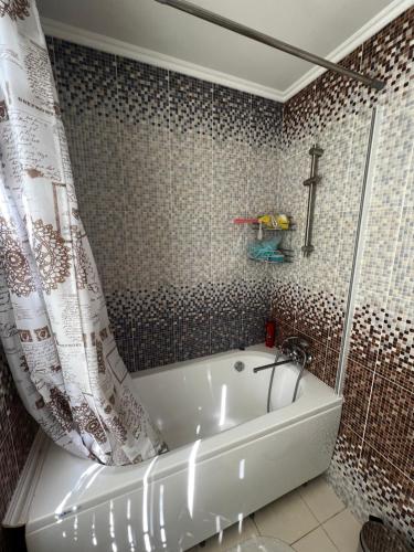 a bathroom with a tub and a shower curtain at EcoVilla in Huluboaia