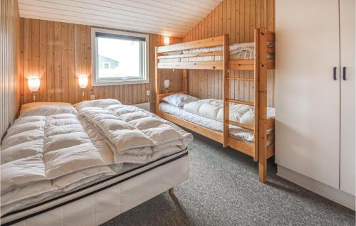 a bedroom with two bunk beds and a window at Nice Home In Thisted With 5 Bedrooms, Sauna And Wifi in Klitmøller